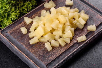 Pineapple canned with pieces on a wooden cutting board