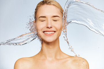 Photo of  young  woman with clean skin and splash of water. Portrait of smiling woman with drops of...