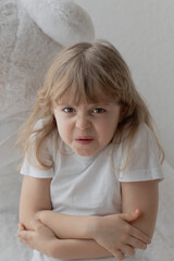 Fototapeta premium Angry girl of 5 years with her plush white teddy bear.