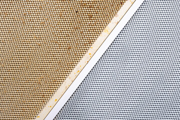 cleaning dirty clogged cooker hood filter from domestic kitchen. dirty and new clean filter. above...