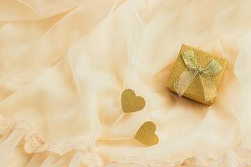 Gift concept for Valentine's Day or woman's birthday. Wedding ring in a gift box on a silk bed with copy space. Festive background concept.