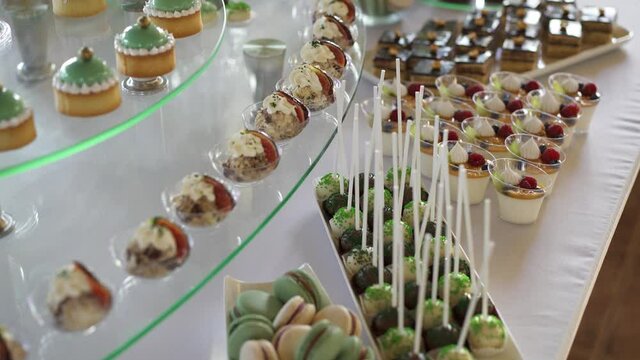 Candy bar at a celebration in a restaurant. Sweets are well laid out on the table.