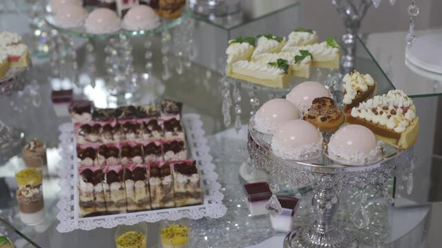Candy bar at a celebration in a restaurant. Sweets are well laid out on the table.
