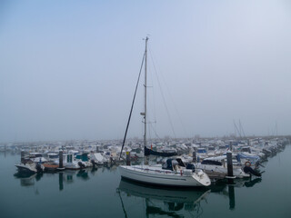 Fototapeta na wymiar Boats in the fog in the bay of Cadiz capital, Andalusia. Spain. Europe. 