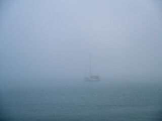 Fototapeta premium Boat in the fog in the bay of Cadiz capital, Andalusia. Spain. Europe. 