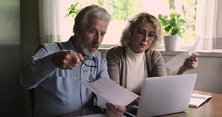 Unhappy middle aged woman made mistake entering data in bank application, feeling stressed managing monthly family budget with older retired husband at home, feeling shocked of financial problems. - Powered by Adobe