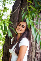 pretty young woman smiling cheerful in green park at tree on summer sunny day, lifestyle people concept