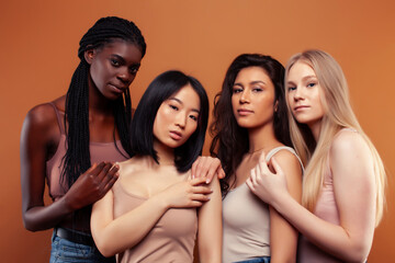 Obraz premium young pretty asian, caucasian, afro woman posing cheerful together on brown background, lifestyle diverse nationality people concept