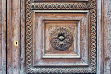 Detail of the panel of an old timber door next to the droor keyhole