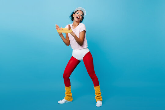 Laughing Black Woman Training With Expander. African Fitness Girl Using Sport Equipment On Blue Background.