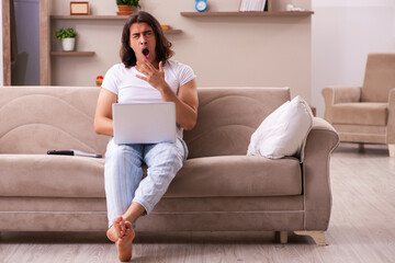 Young lazy man in oversleeping concept at home