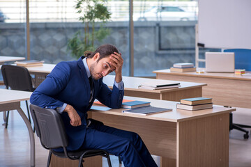 Young male teacher in suit in the classroom