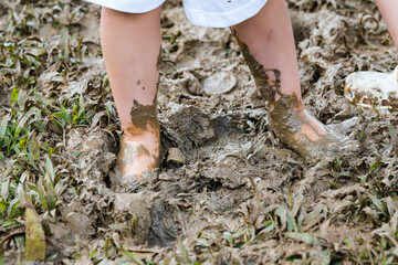 a toddler playing with the mud