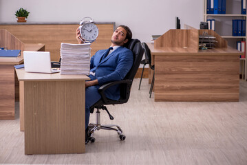 Young male employee unhappy with excessive work in the office