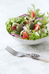 Salad with Green Olives, Tomatoes and Feta Cheese. Bright wooden background.	