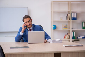 Young male employee sitting in the office in front of whiteboard