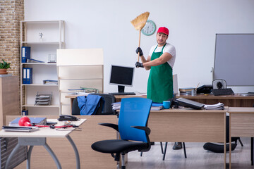 Young male contractor cleaning the office