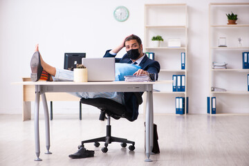 Young male employee during pandemic at workplace