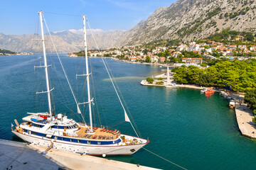 Fototapeta na wymiar A sailing yacht is harbored on the Boka bay at the port of the European medieval city of Kotor, Montenegro.