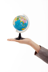 A hand holding a globe