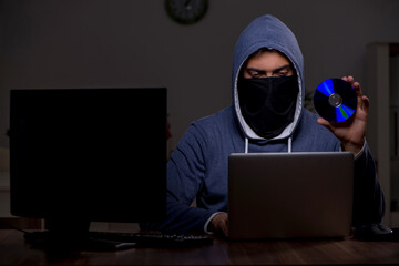 Male hacker hacking security firewall late in office