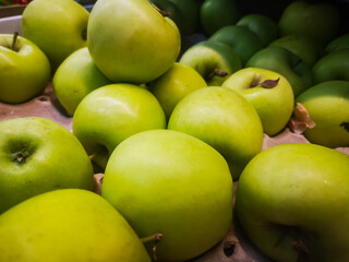selling green apples in a box by weight in a supermarket