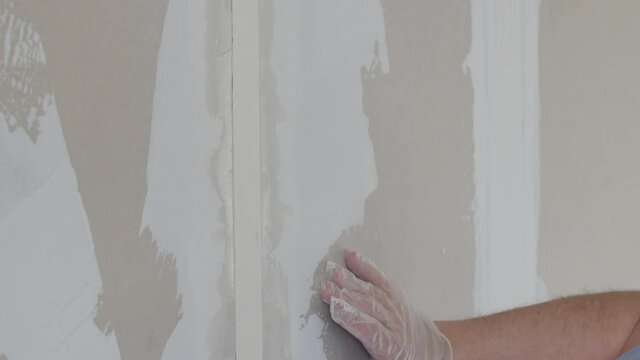 Craftsman working with plaster gypsum ceiling for interior build gypsum board. laminated plasterboard plastering join tape: DIY detail. worker hand using gypsum plaster ceiling joints at construction