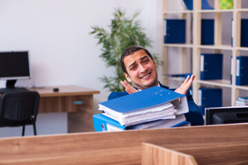 Young male employee unhappy with excessive work in the office