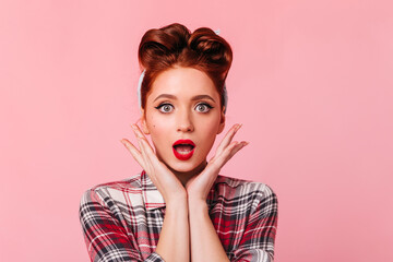 Amazed ginger woman posing in checkered shirt. Front view of shocked pretty girl isolated on pink background.