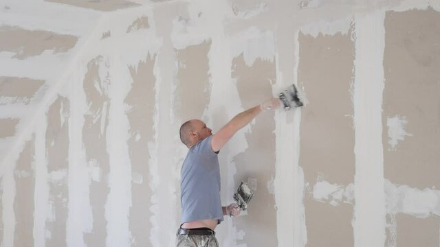 Working process of plasterboard drywall for making gypsum walls in apartment under construction, remodelling, renovation, extension, restoration and reconstruction. DIY concept. Drywall installation