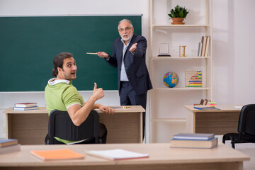 Aged teacher and male student in the classroom