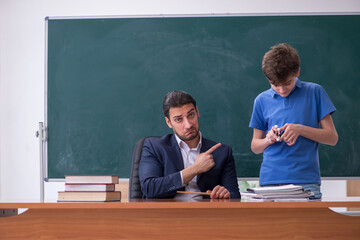 Young male teacher and schoolboy in the classroom