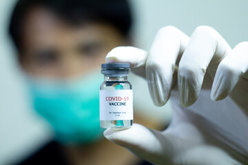 young doctor showing covid-19 vaccine bottle