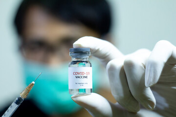 man showing covid-19 vaccine bottle and the syringe