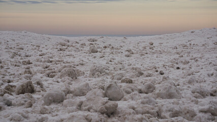 Frozen shoreline of Lake Michigan after a winter storm. Snow drifts formed at the water's edge and ice balls formed  from the rolling waves. Taken at Gillson Beach in Wilmette, Illinois.