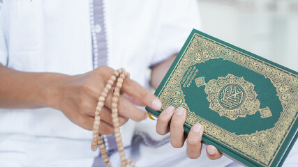 Obraz premium A portrait of an asian muslim man holding Quran and tasbih