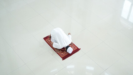A portrait of an asian muslim man pray at mosque, the pray name is sholat, sujud movement on sholat