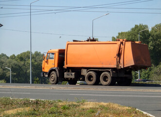 Orange garbage truck. KamAZ truck. City street. Ust-Kamenogorsk (kazakhstan)