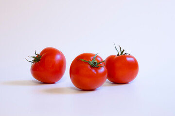 three red tomatos on white background