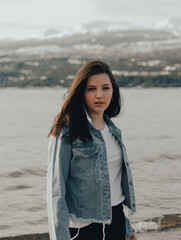 portrait of a beautiful young girl with blue jacket looking at the camera at sunrise