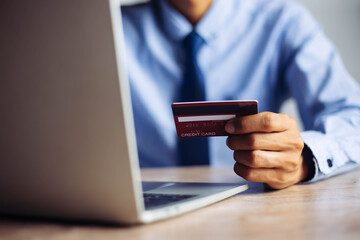 ้Online payment hands holding credit card and using laptop. Online shopping concept.