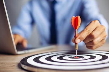 Businessman holding a darts aiming at the target center business goal concept - business targeting,...