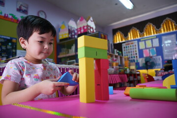 child playing with blocks.asian girls are playing toys in the classroom alone