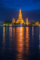 Fototapeta premium Beautiful vertical view of famous Wat Arun, the Buddhist temple of dawn, in the light of the blue hour after sunse