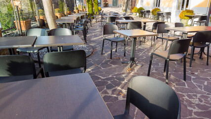 Bergamo, Italy. Empty bar tables due to the Covid-19 or Coronavirus pandemic. Light lockdown time. Bars and restaurants closed due to the absence of tourists. Desolation and sadness for empty city