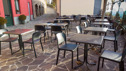 Bergamo, Italy. Empty bar tables due to the Covid-19 or Coronavirus pandemic. Light lockdown time. Bars and restaurants closed due to the absence of tourists. Desolation and sadness for empty city