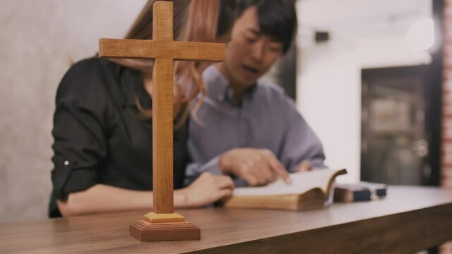 Young missionary is giving Bible advice to young woman in church. 