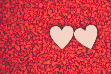 Close-up two hearts for love symbol on a red sand background. Concept the day of love 14 February happy valentine's day.