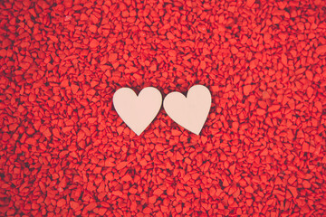 Close-up two hearts for love symbol on a red sand background. Concept the day of love 14 February happy valentine's day.