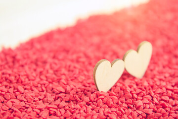 Close-up two hearts for love symbol on a red sand background. Concept the day of love 14 February happy valentine's day.